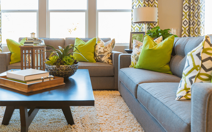 Clean living room with couches, center table, and a carpet used as home staging area