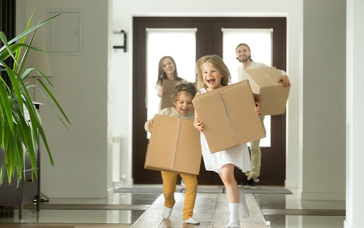 Young children run into new home with boxes.